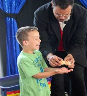Pre-school boy laughs at birthday party magician